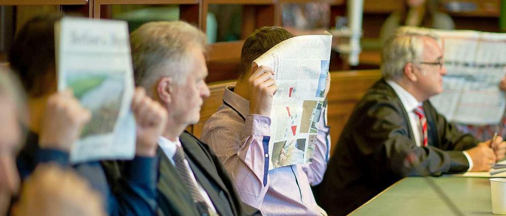 Die Angeklagten im Jonny K.-Prozess verstecken sich hinter Zeitungen.