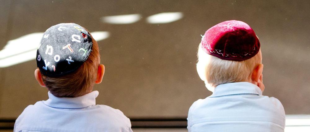 Zwei Jungen mit Kippa sitzen in einer jüdischen Schule.