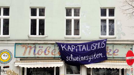 "Kapitalismus Schweinesystem" hängt an einem Haus in Oranienstraße in Berlin-Kreuzberg. 
