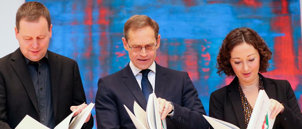 V.l.n.r: Klaus Lederer (Linke), Michael Müller (SPD) und Ramona Pop (Grüne) schauen in den Koalitionsvertrag.