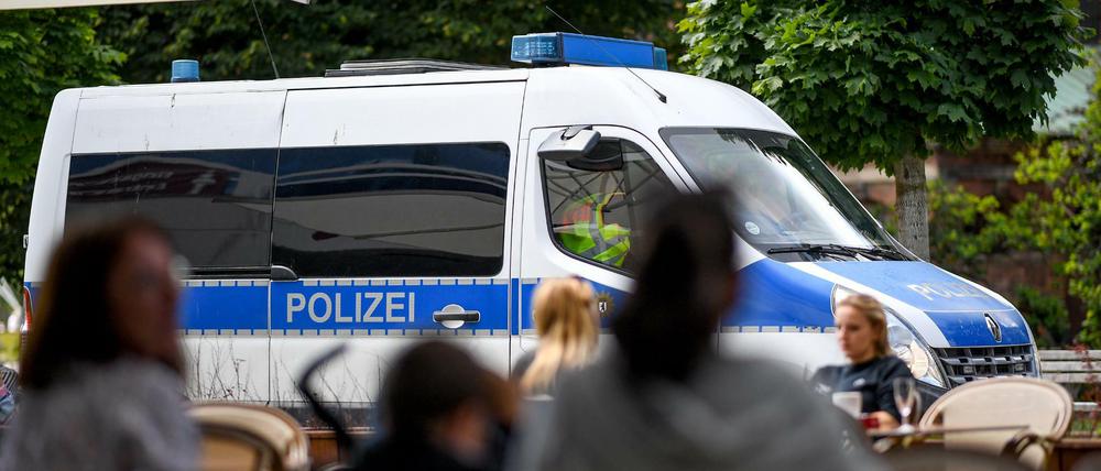 Ein Einsatzfahrzeug der Polizei fährt an einem Lokal am Alexanderplatz vorbei. Nachdem die Corona-Regeln häufig missachtet wurden, erwägt die Gesundheitssenatorin ein Alkoholverbot in Bars.