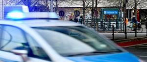 Polizeiwagen mit Blaulicht am Kottbusser Tor, im Hintergrund ein U-Bahn-Eingang.