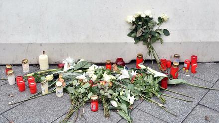 Blumen und Kerzen stehen an einer der Betonbarrieren auf dem Breitscheidplatz. 