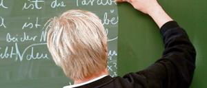 Ein Lehrer wischt während des Mathematik-Unterrichts die Tafel sauber.