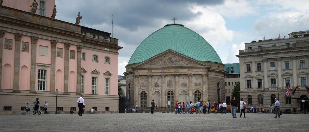 Die St. Hedwigs-Kathedrale in Berlin-Mitte. und der Bebelplatz unter drohenden Wolken.
