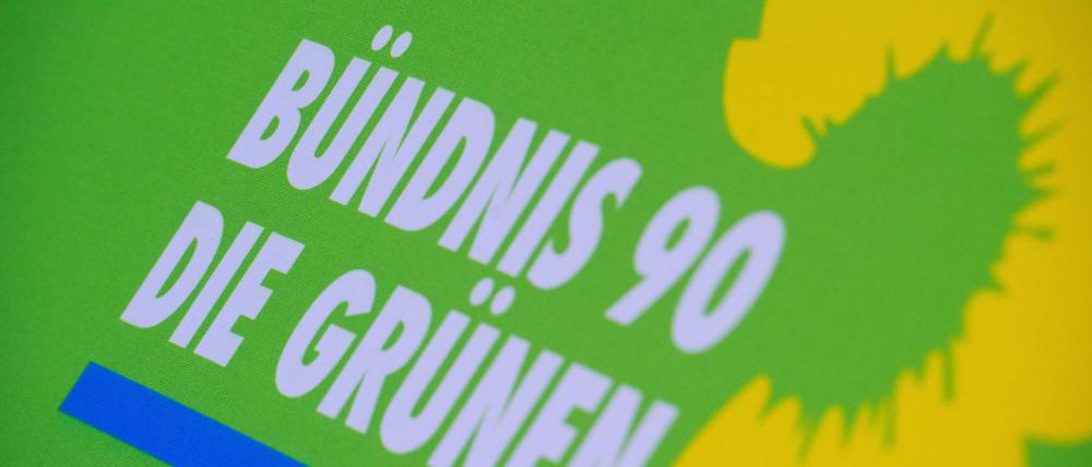 Das Logo von Bündnis 90/Die Grünen steht auf einem Aufsteller der Partei. 