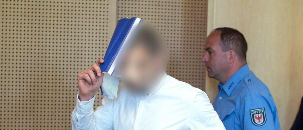 Mario K. verdeckt während seines Prozesses sein Gesicht mit einem Hefter. (Archivbild 2015)