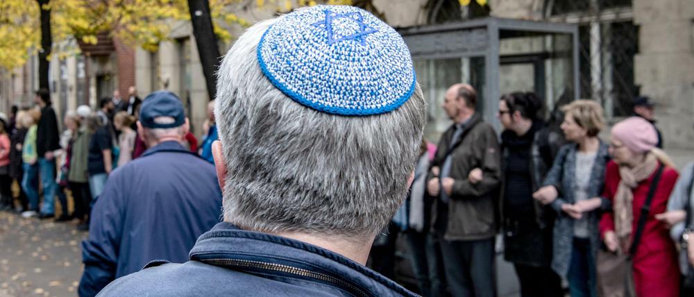 Ein Mann mit Kippa steht vor der Neuen Synagoge vor einer Menschenkette des Bündnisses für ein weltoffenes und tolerantes Berlin.