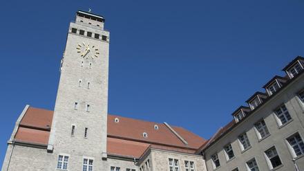 Blick von unten auf das Rathaus Neukölln unter blauem Himmel.