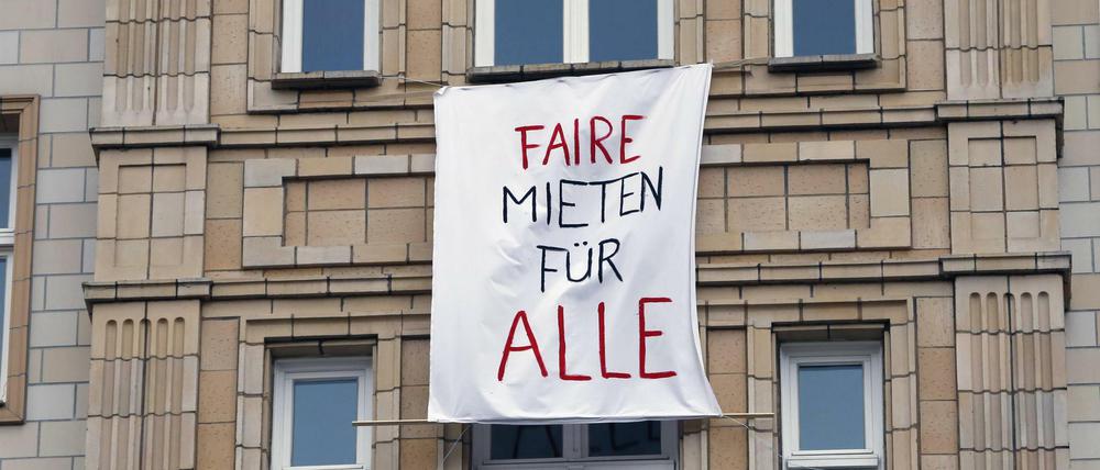 Mit Transparenten an den Fenstern protestieren Mieter in der Karl-Marx-Allee in Berlin gegen den Verkauf von Wohnungen. 