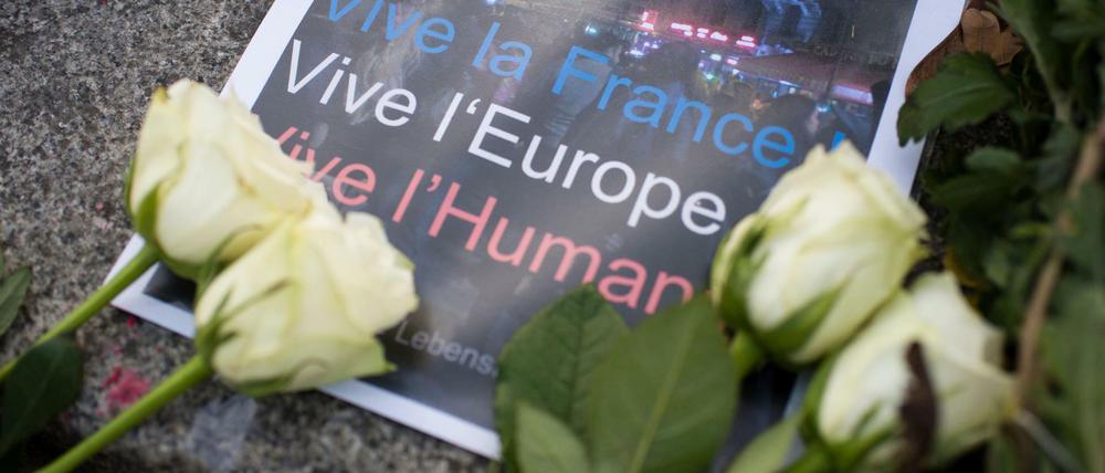 dpatopbilder - Ein Poster mit der Aufschrift «Vive la France! - Vive l'Europe! - Vive l'Humanite!» (Es lebe Frankreich! - Es lebe Europa! - Es lebe die Menschlichkeit!) liegt am 14.11.2015 von weißen Rosen umrahmt vor der Botschaft von Frankreich auf dem Pariser Platz in Berlin. Bei einer Serie von Terroranschlägen in Paris wurden mindestens 120 Menschen getötet. Foto: Gregor Fischer/dpa +++(c) dpa - Bildfunk+++