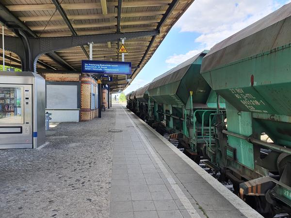 Ein Güterzug mit Schotter am Bahnsteig in Marienfelde