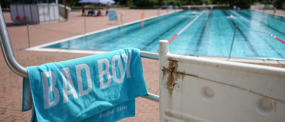 Ein Handtuch mit dem Aufdruck "Bad Boy" liegt auf dem Geländer des Sprungturms im Sommerbad Pankow.