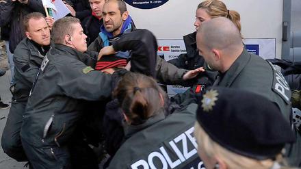 Polizisten tragen einen Demonstranten gegen einen Aufmarsch der rechtsextremen NPD am Freitag in Berlin von der Marienfelder Allee.