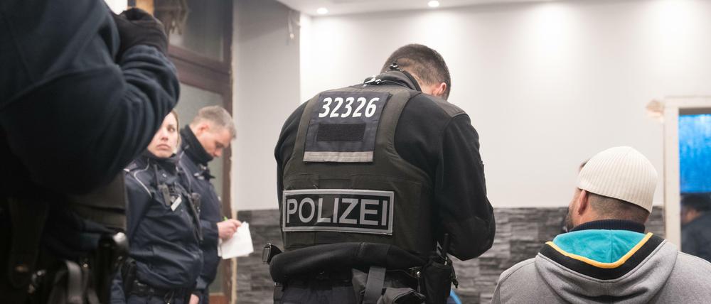  Beamte der Berliner Polizei, Zoll und Ordnungsamt durchsuchen ein Café. 