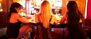 Prostituierte sitzen in einem Bordell an einer Bar. 