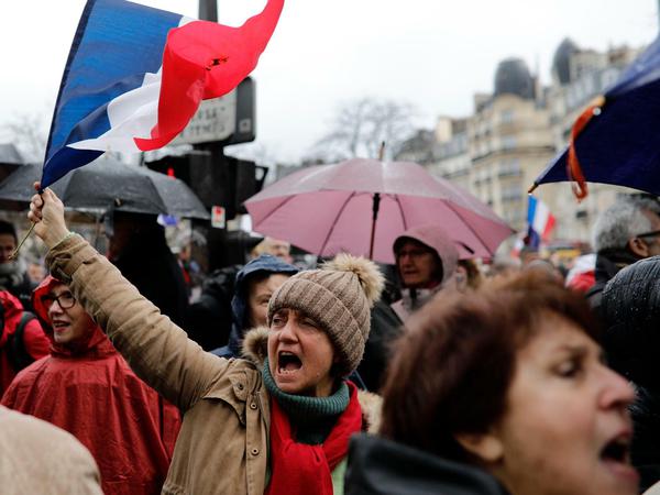 Gegendemonstranten, die sich die "Roten Schals" und "Blauen Westen" nennen, protestieren in Paris gegen die "Gelbwesten".