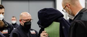 Ein Angeklagter aus Berlin verdeckt im Grünen-Gewölbe-Prozess in Dresden sein Gesicht.