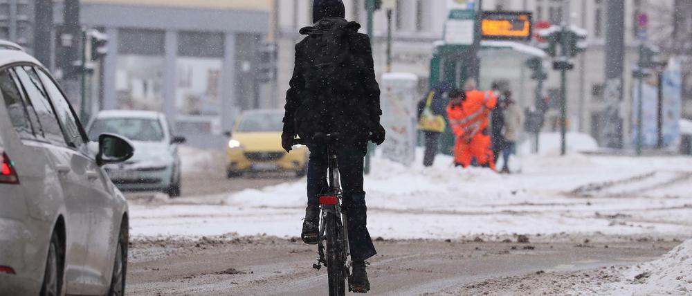 Ein Fahrradfahrer fährt in Potsdam auf der Straße. Die Radwege sind bei Schnee und Eis kaum nutzbar - auch in Berlin ist das so.
