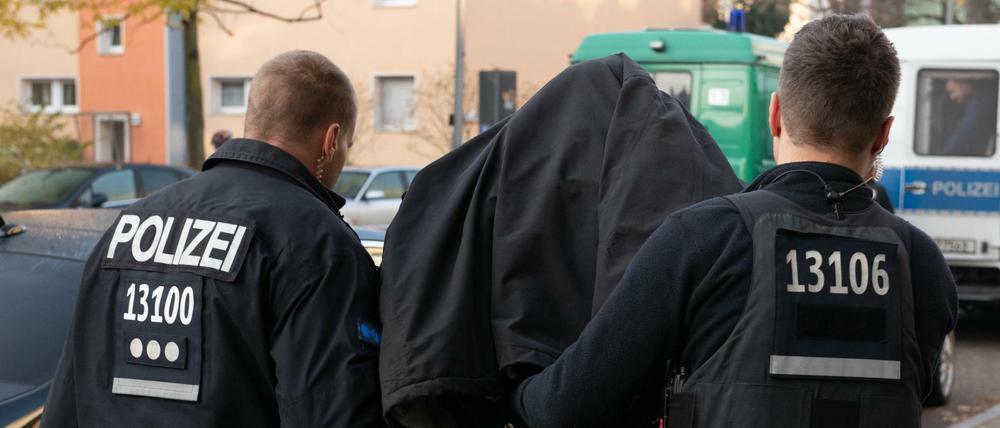 Polizeibeamte nehmen einen Verdächtigen bei einer Razzia in Tempelhof fest. 