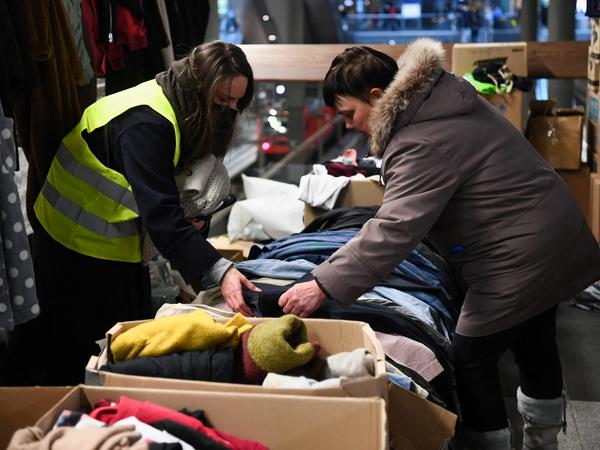 Eine Freiwillige hilft einer Ukrainerin am Berliner Hauptbahnhof mit Spenden. 