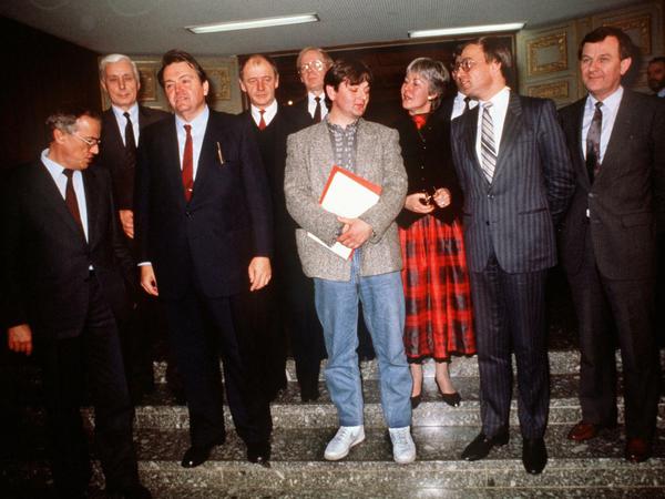Der Pionier unter den turnschuhtragenden Politikern: Joschka Fischer (Mitte), erster grüner Umwelt- und Energieminister einer Landesregierung. Zum Tag der Vereidigung vor dem hessischen Parlament in Wiesbaden am 12. Dezember 1985 trug er ein Modell des US-Herstellers Nike.