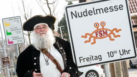Rüdiger Weida von der «Kirche der fliegenden Spaghettimonster» steht neben seinem Schild «Nudelmesse» in Templin (Brandenburg).