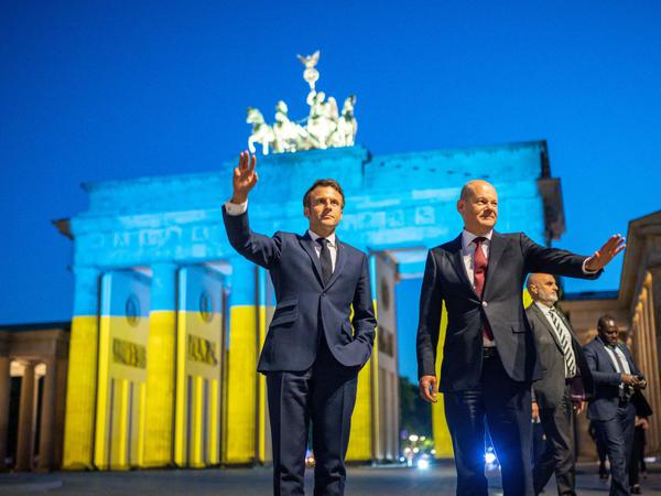 Bundeskanzler Olaf Scholz und Frankreichs Präsident Emmanuel Macron besuchten nach einem Treffen gemeinsam das beleuchtete Brandenburger Tor.