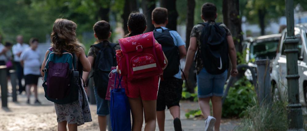 Schüler der Eichendorff-Grundschule in Charlottenburg gehen auf einem Bürgersteig. 