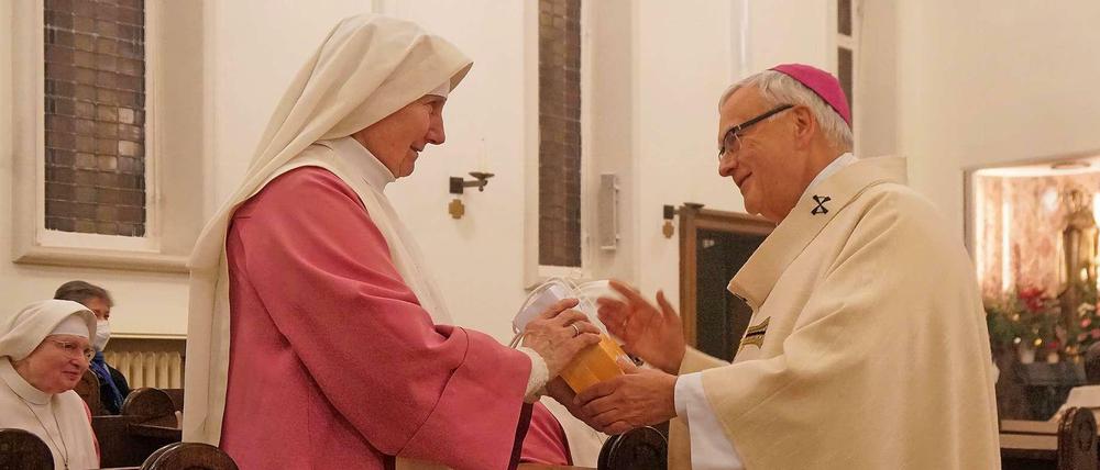 Eine der Nonnen erhält ein Abschiedsgeschenk von Erzbischof Heiner Koch.
