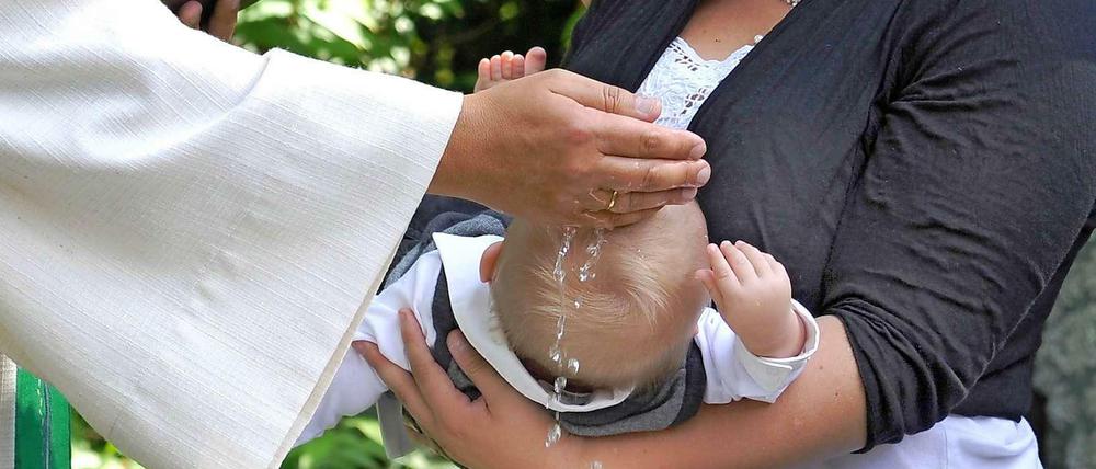 Ein Kind wird getauft.