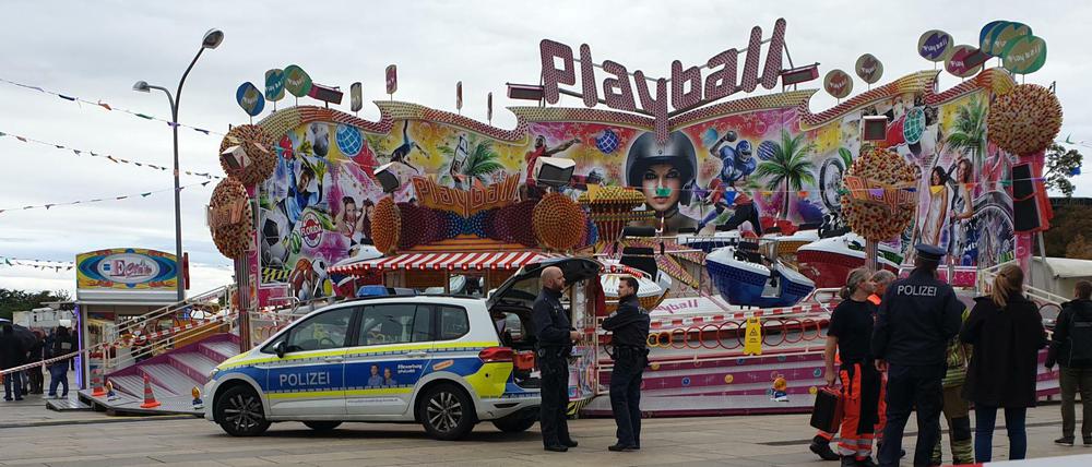 Polizisten und ein Polizeiwagen stehen vor dem Fahrgeschäft „Playball“
