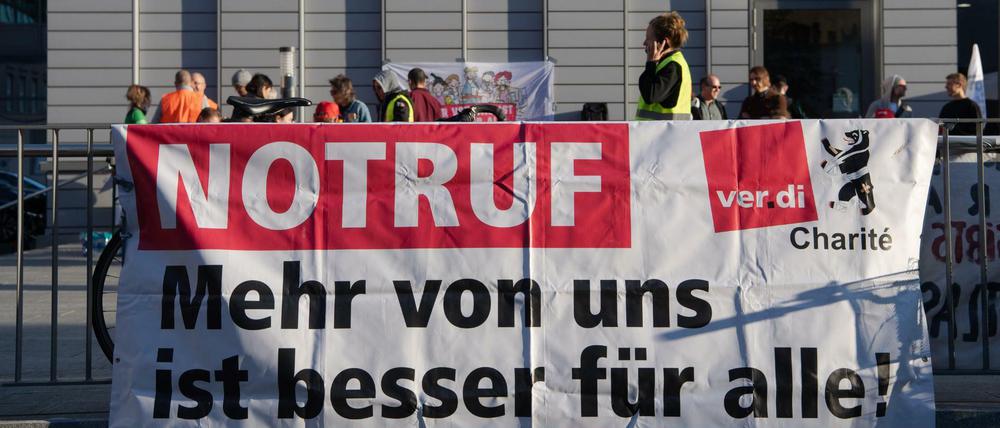 NOTRUF steht in Großbuchstaben auf einem Transparent am Bettenhaus der Charité. Beschäftigte aller landeseigenen Berliner Kliniken streiken seit dem 7. September. Bei den Vivantes-Töchtern schwelt nun der Tarifstreit weiter.