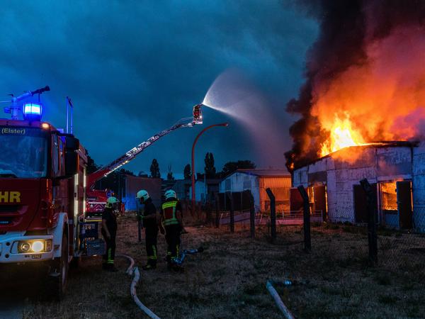 Einsatzkräfte der Feuerwehr versuchen einen Gebäudebrand in der Region Falkenberg /Elster zu löschen. 
