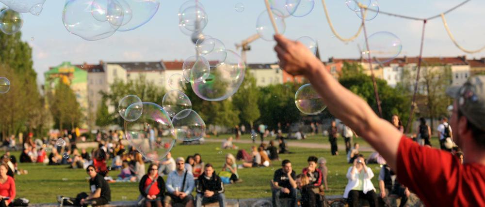 Ein Kleinkünstler macht im Berliner Mauerpark große Seifenblasen. Nun sollen Teile des Parks bebaut werden.