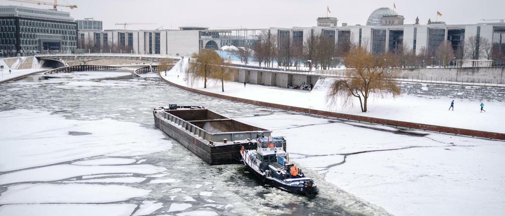 Ein Schubverband bahnt sich bei frostigen Temperaturen den Weg durch das Eis auf der Spree im Berliner Regierungsviertel.
