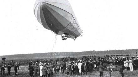 Ein Zeppelin schwebt über einer Zuschauermenge auf dem Tempelhofer Feld. Die Schwarzweiß-Aufnahme entstand am 29. August 1909.