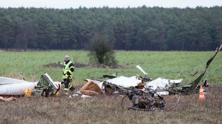 Die Trümmer eines Flugzeugs liegen nach einem Absturz auf einem Feld verstreut.