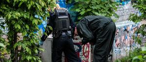 Polizeibeamte suchen im Görlitzer Park nach versteckten Drogen.