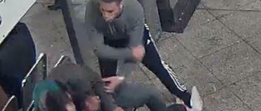 Einer der Angreifer schlägt am U-Bahnhof Mehringdamm auf einen Obdachlosen ein. 