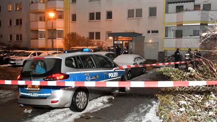 Einsatzkräfte der Polizei und ein Polizeiwagen stehen in Berlin vor einem Wohnhaus an der Ribnitzer Straße. 