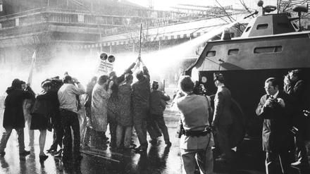 Demonstranten mit Kreuz stehen am Ostersonntag 1968 vor einem Wasserwerfer der Polizei auf dem Kurfürstendamm. Laut Polizeipräsident Moch gab es seit Juni 1967 vier ruhige Wochenende für die Polizisten.
