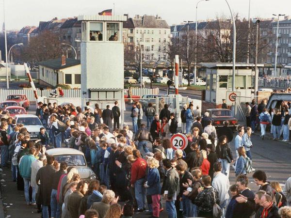Am Morgen nach dem Mauerfall ziehen Kolonnen von Trabbis durch West-Berlin. Am Grenzübergang in der Bornholmer Straße werden sie schon von begeisterten West-Berlinern begrüßt.