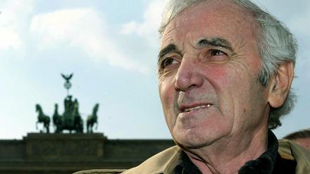 Der französische Sänger Charles Aznavour. steht vor dem Brandenburger Tor.