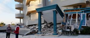 Nach dem Erdbeben stehen zwei Männer neben einem beschädigten Gebäude. 