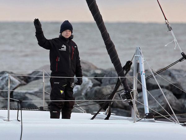  Greta Thunberg steht an Bord des Katamarans «La Vagabonde» und winkt.