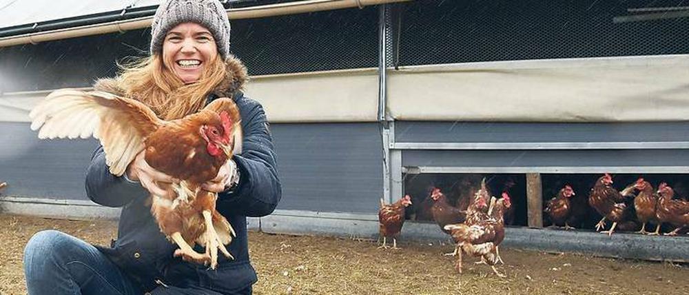 Fröhliches Flattern. Karoline Hesterberg vor ihrem mobilen Hühnerstall. Rund 1000 Hennen picken auf Gut Hesterberg das ganze Jahr Futter auf der Wiese. Im Stall wandern die frisch gelegten Eier aufs Band.