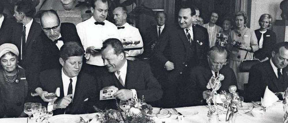 Kennedy in Berlin. Am 26. Juni 1963 spricht JFK die legendären Worte: "Ich bin ein Berliner". Zum Lunch mit Bundeskanzler Konrad Adenauer und Berlins Regierendem Bürgermeister Willy Brandt gibt es danach Rinderfilet mit Spargel und Paprika.