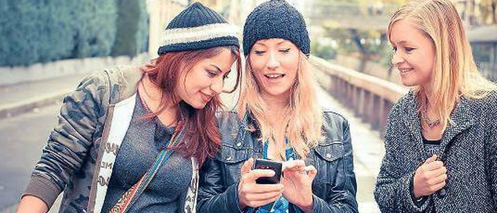Chillen. Junge Mädchen suchen auf ihrem Smartphone nach der nächsten Party oder einem Partner für ein Date. 