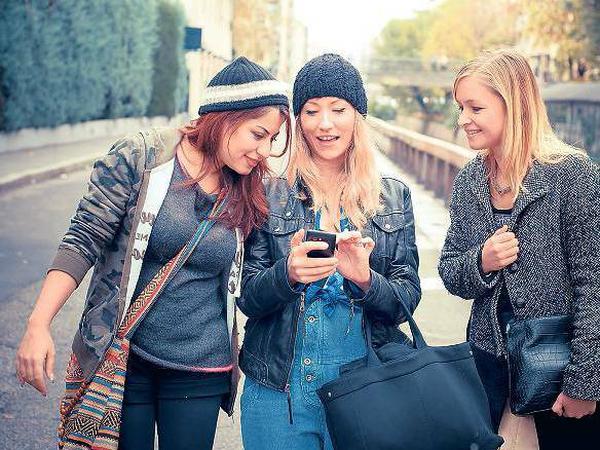 Chillen. Junge Mädchen suchen auf ihrem Smartphone nach der nächsten Party oder einem Partner für ein Date. 